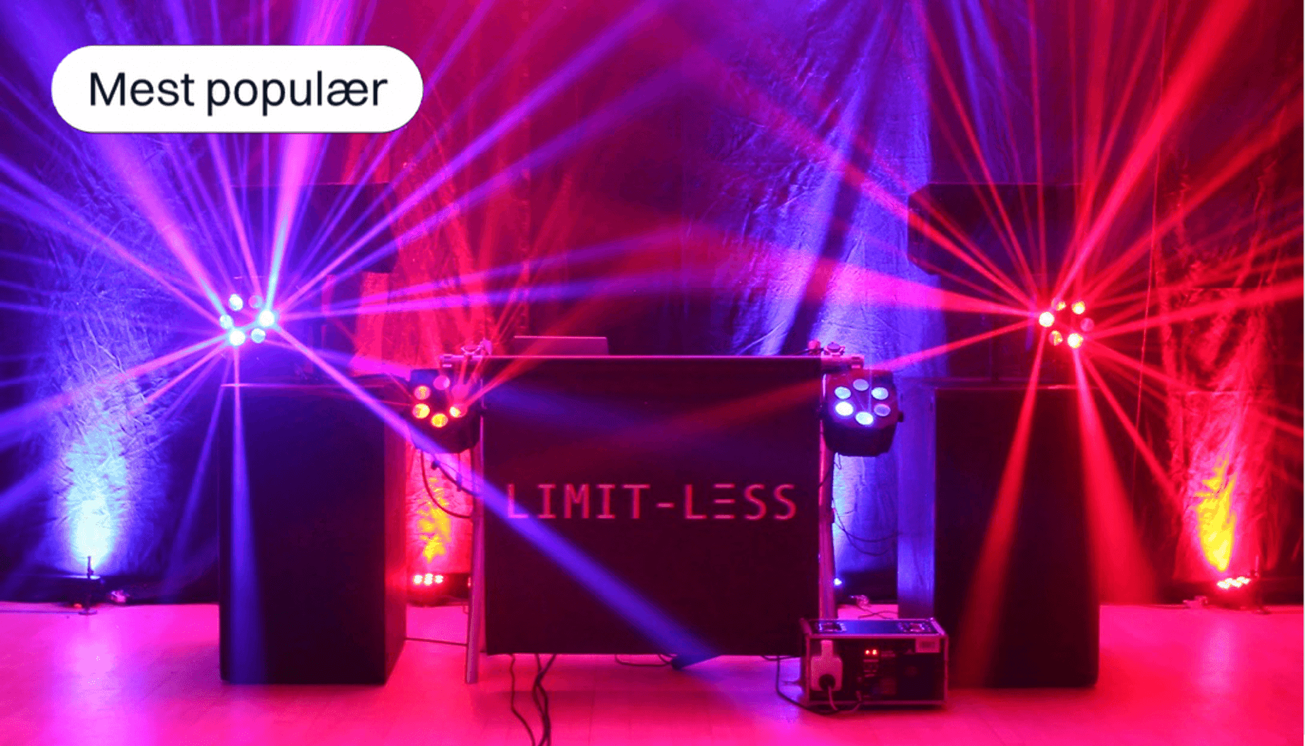 Stage setup with colorful lighting effects and 'Limit-less' logo on the DJ booth.