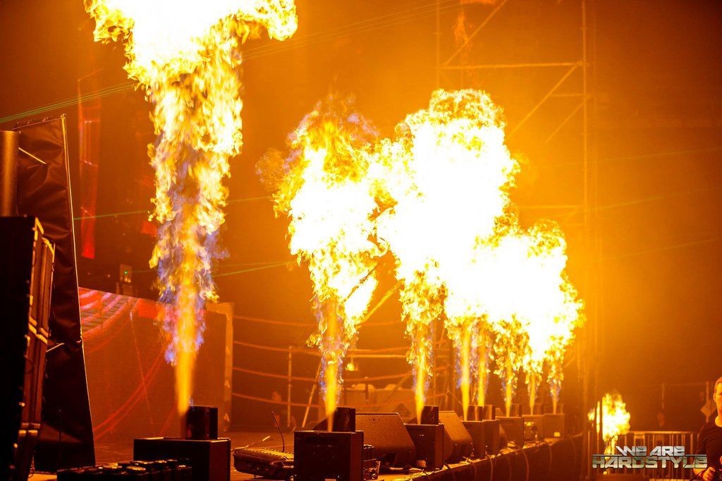 Stage with bright pyrotechnic flames shooting upward during a concert.