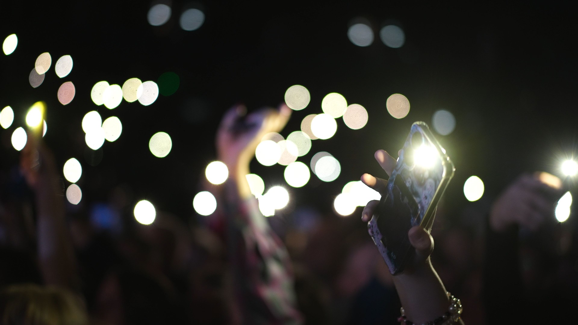 Music performance people wave phone flash lights. Flashlights concert atmosphere